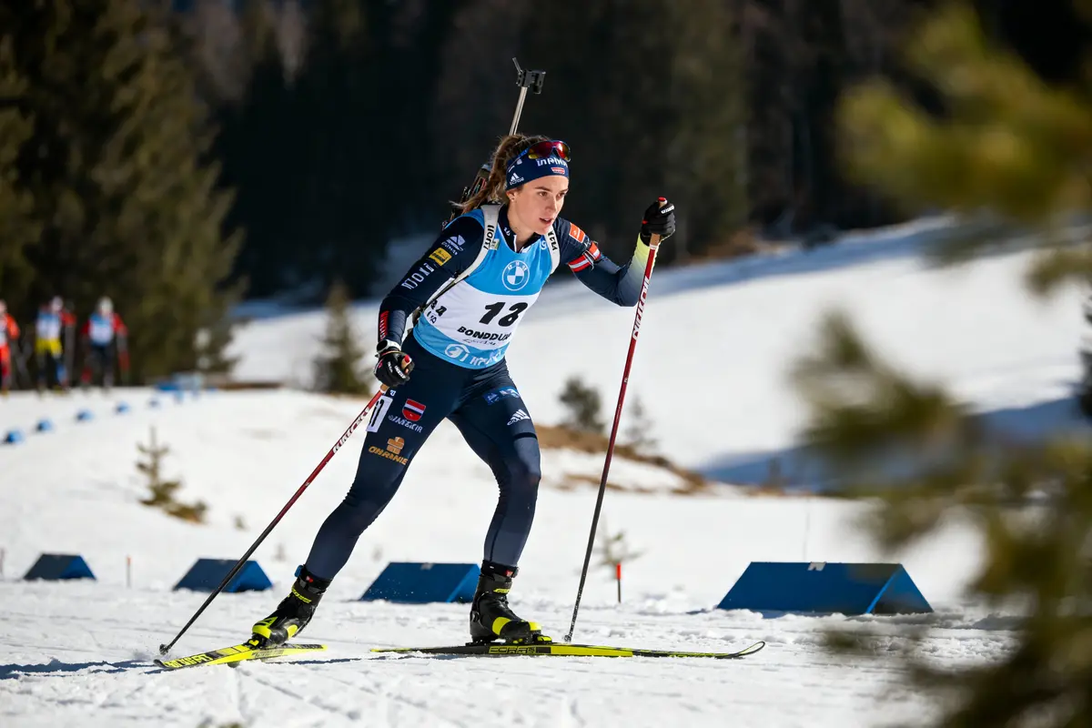 Skieuse de fond en compétition sur piste enneigée, portant un dossard numéro 13, avec équipement complet.