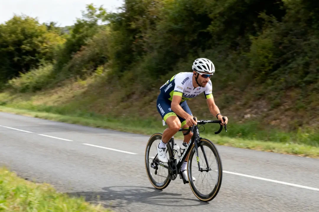 Cycliste Nicolas Jalabert en course sur une route de campagne verdoyante