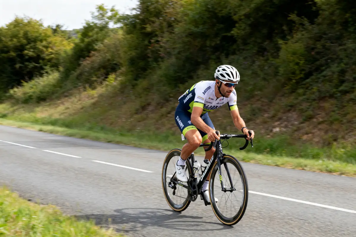 Cycliste Nicolas Jalabert en course sur une route de campagne verdoyante