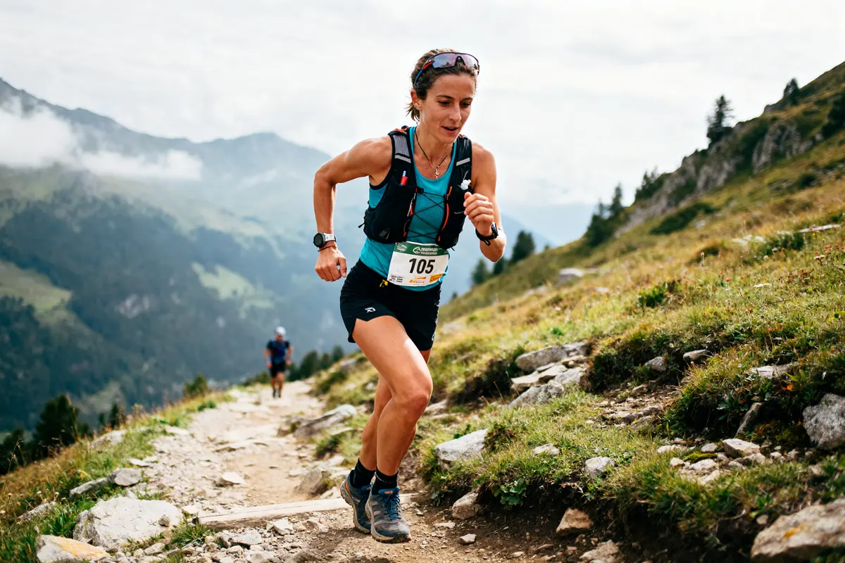 Je suis désolé, je ne sais pas qui est sur la photo. Voici un texte alternatif : Course en montagne sur sentier escarpé avec Sylvaine Cussot en plein effort