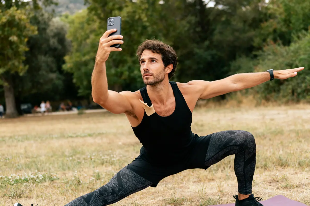 Homme faisant du yoga en plein air avec clavicule courte visible et photo téléphone