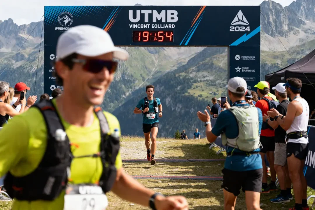Coureur franchit la ligne d'arrivée sous l'arche UTMB montrant le résultat UTMB 2024