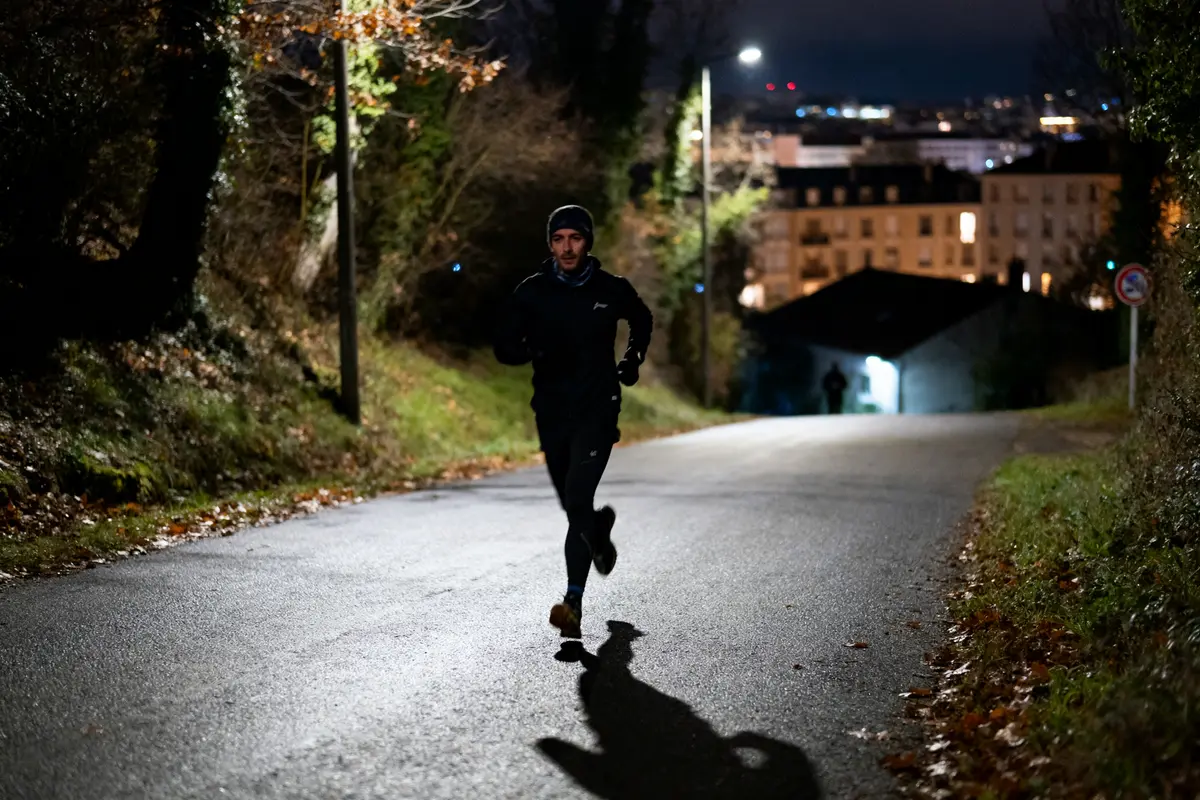 Homme courant la nuit en ville sur route pour Saintexpress