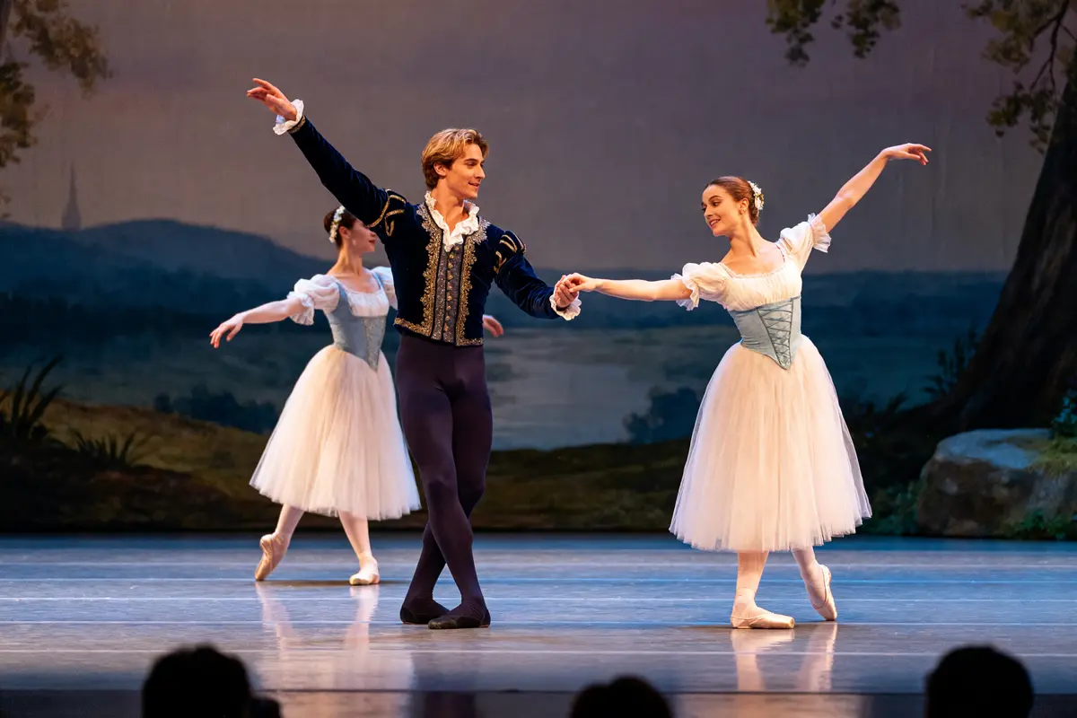 Danseurs exécutant une scène du ballet Giselle en costumes traditionnels sur scène élégante