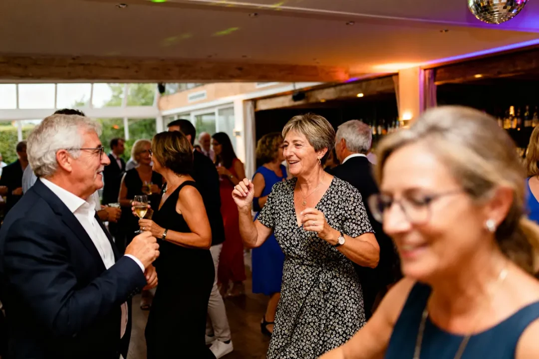 Gens dansant joyeusement lors d'une réception avec playlist de mariage en fond