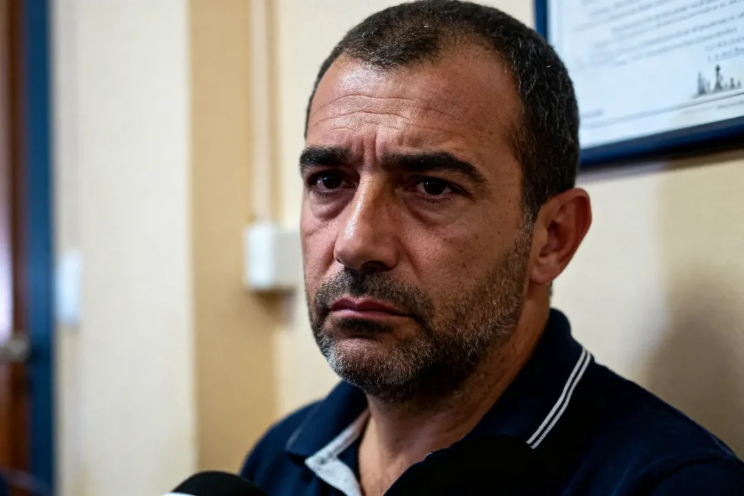 Homme sérieux dans un bureau avec certificat Bellicou au mur derrière lui