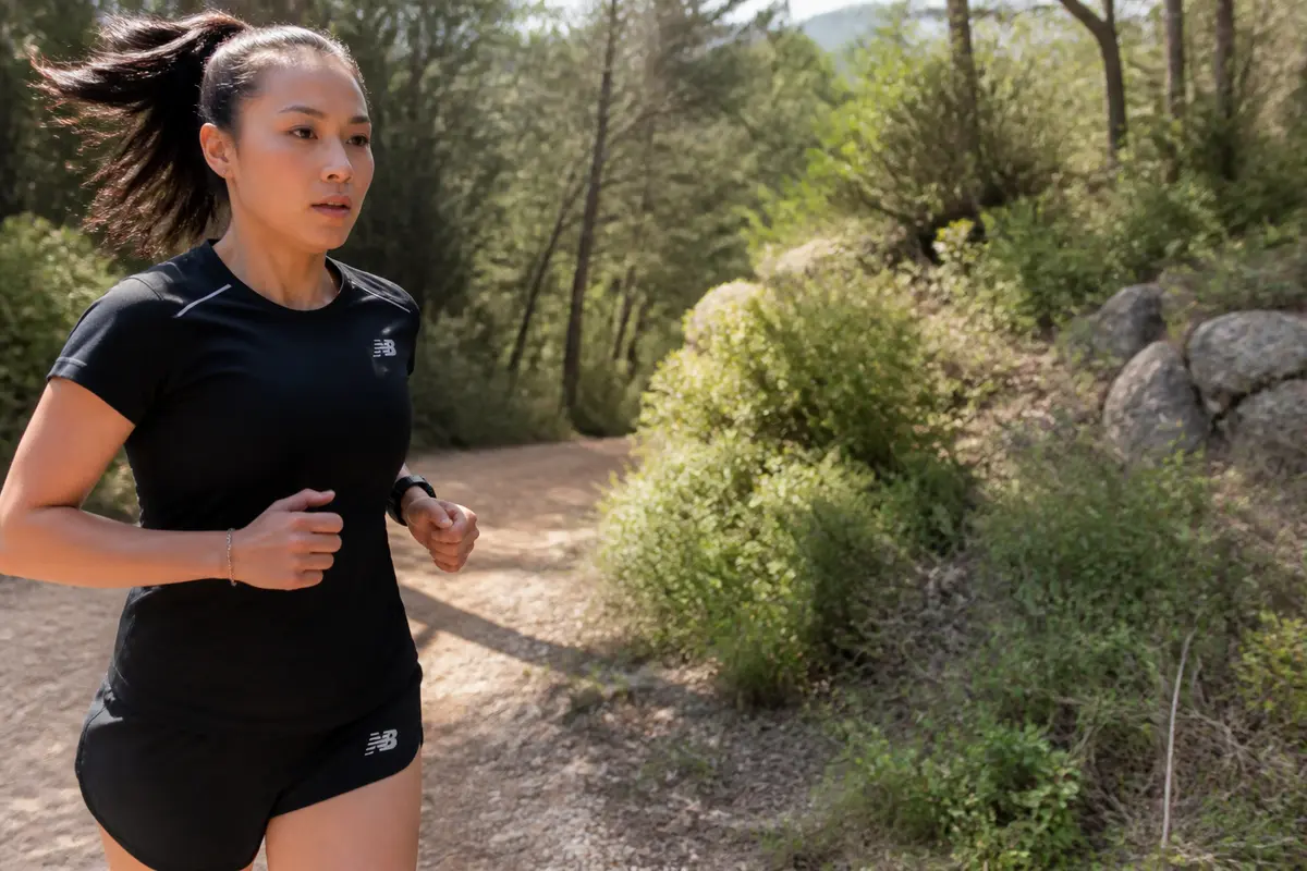 Laurie Phai en train de courir sur un sentier forestier ensoleillé